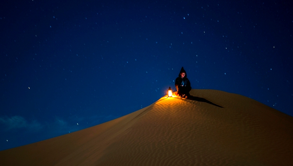 Bedouin watch light above desert camp